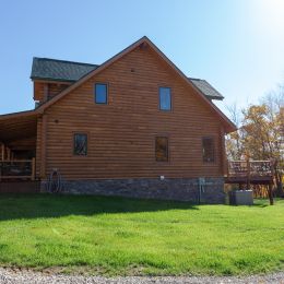Swedish Cope Log Home with Stone Covered Foundation