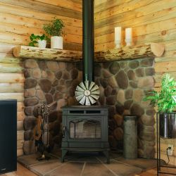 Wood Burning Stove with Stone Covered Raised Mantle Behind 