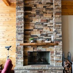 Stone Covered Fireplace with Log Mantle
