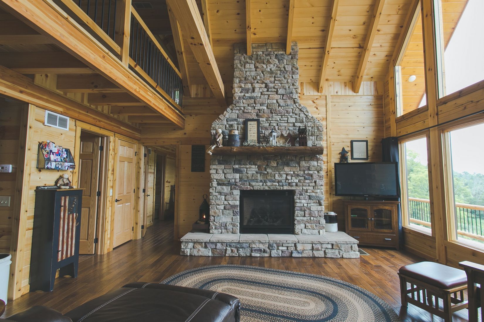 Stone Covered Fireplace with Log Mantle and Raised Hearth