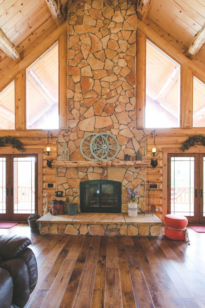 Stone Veneer covered fireplace with a log mantle and raised hearth